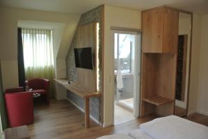 een slaapkamer met een open haard en een tv in een kamer bij Hotel Jägerhof in Weibersbrunn