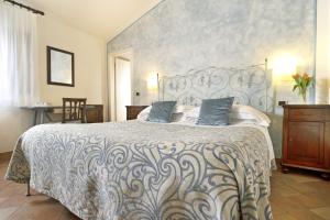 a bedroom with a large bed with blue pillows at Borgo Grondaie in Siena