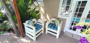 two chairs and a table on a porch at Paradise in the City Cottage Two in Port Elizabeth