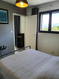 a bedroom with a large bed and a window at Appartement F2 avec terrasse de 35 m2 Bomorto - Porticcio in Porticcio
