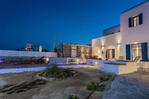 a house with lights on the side of it at night at Punda Villas Paros in Kampos Paros