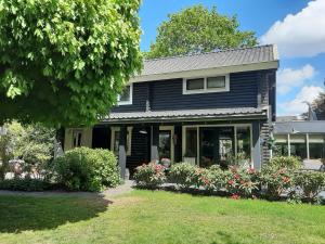 a black house with flowers in the yard at BedandBreakfast Casa Martina in Kortgene