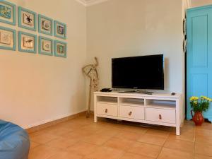 una sala de estar con TV en un armario blanco en Casa na Praia Verde, en Praia Verde