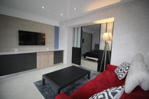 ein Wohnzimmer mit einem roten Sofa und einem TV in der Unterkunft Bel appartement 53 m2 in Ruy