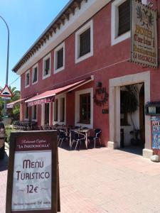 ein Restaurant mit einem Schild vor einem Gebäude in der Unterkunft Hotel Rural Carlos I in Garganta la Olla