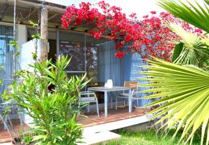 een patio met een tafel en rode bloemen bij Quinta Luz do Sol in Moncarapacho