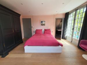 1 dormitorio con 1 cama grande con almohadas rojas en So Touquet, en Le Touquet-Paris-Plage