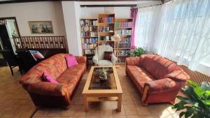 a living room with two couches and a coffee table at Pension Velber in Neugarmssiel