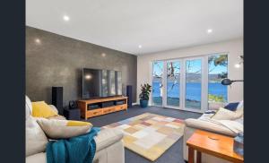 a living room with a couch and a television at On the Huon River in Lymington