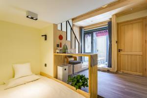 a bedroom with a bed and a staircase with a window at Templeside Beijing in Beijing
