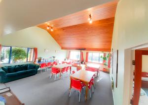 a room with tables and chairs and a couch at Tongariro River Retreat in Turangi