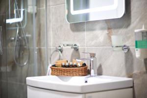 d'une salle de bains avec un panier au-dessus d'un lavabo. dans l'établissement Rusty Sands apt Spa n Pools Beach resort, à Mamaia Nord – Năvodari