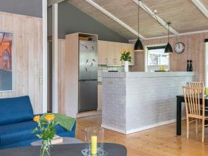 埃伯爾措夫特的住宿－Plush Holiday Home in Ebeltoft with Terrace，厨房以及带蓝色沙发和台面的客厅。