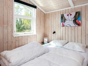 埃伯爾措夫特的住宿－Plush Holiday Home in Ebeltoft with Terrace，卧室配有白色的床和窗户。