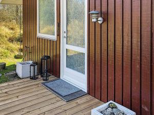 une porte d'entrée d'une maison avec une terrasse couverte dans l'établissement 4 person holiday home in L s, à Læsø