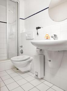 a white bathroom with a sink and a toilet at FIP Park Achtern Diek in Insel Poel