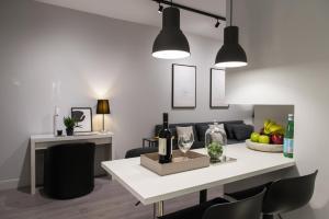 ein Wohnzimmer mit einem Tisch mit Weinflaschen und Gläsern in der Unterkunft JB Luxury Suites in Nafplio