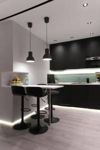 a kitchen with black cabinets and a table with chairs at JB Luxury Suites in Nafplio