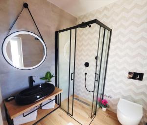 a bathroom with a shower and a black sink at Boutique Villa Revelin in Pag