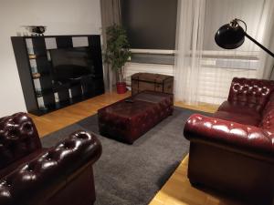 a living room with leather furniture and a flat screen tv at Apartment West - Michael in Stuttgart