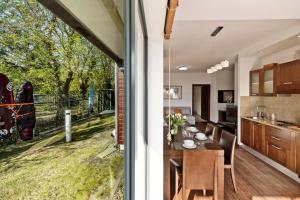 a kitchen and dining room with a view of a yard at Apartamenty.in Jurata Mestwina in Jurata