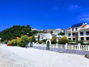 a row of houses on a street with a white fence at Apartments Johnny in Podstrana