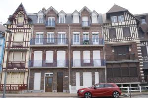 a red car parked in front of a building at Résidence les Charmettes in Mers-les-Bains