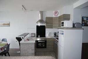 a kitchen with a stove and a refrigerator at Résidence les Charmettes in Mers-les-Bains