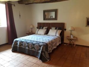 1 dormitorio con cama y espejo en la pared en Domaine de la Piale, en Fons