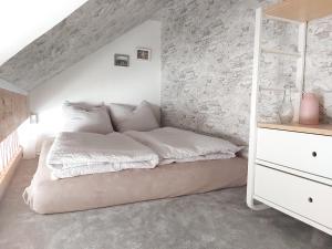 uma cama num quarto com uma parede de pedra em Tova Cologne em Großkönigsdorf