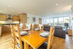 a kitchen and dining room with a wooden table and chairs at Headland Beaches in Newquay