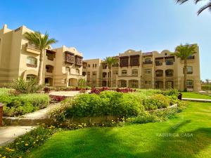 a large apartment building with a garden in front of it at Cozy Family 3 BR apartment by the sea in Marsa Alam City