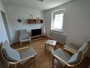 ein Wohnzimmer mit Stühlen und einem Flachbild-TV in der Unterkunft Holiday Home Debacher in Kappel-Grafenhausen