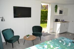 a bedroom with two chairs and a table and a tv at Studio 38 in Zandvoort