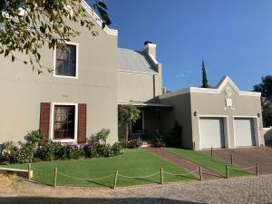a house with a lawn in front of it at La Gratitude Self catering cottage in Franschhoek