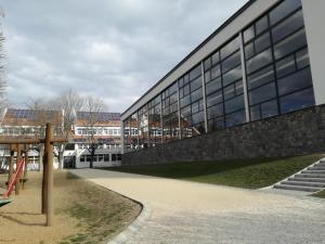 a large glass building with stairs in front of it at Tihany Község Önkormányzat - Ifjúsági Szállás in Tihany