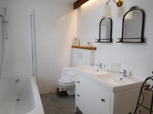 een witte badkamer met een wastafel en een toilet bij Appartements Kornberg Gütl in Haus im Ennstal