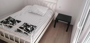 a white bed with black and white pillows and a table at Novalja centar in Novalja