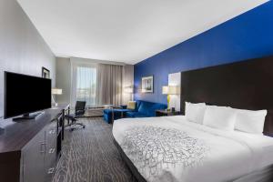 a hotel room with a bed and a flat screen tv at La Quinta by Wyndham Odessa North - Sienna Tower in Odessa