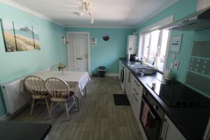 a kitchen with a table and a dining room at Easdale House Apartments in Inverness