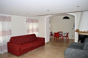 a living room with a red couch and a table at La Casetta di Lettopalena in Lettopalena
