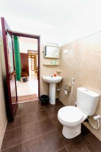 La salle de bains est pourvue de toilettes et d'un lavabo. dans l'établissement Water Front Home Stay, à Anurâdhapura