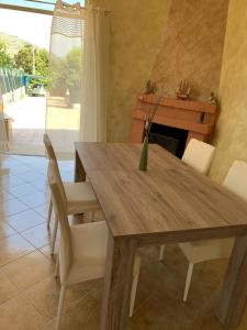 a dining room table with white chairs and a fireplace at Acquamarina in Gaeta