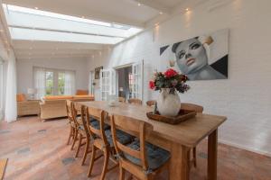 a dining room with a table and a vase with flowers at Prachtig gelegen vrijstaand landhuis in Hansweert