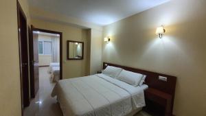 a bedroom with a bed and a mirror on the wall at Sun Galicia Hotel y Apartamentos in Sanxenxo