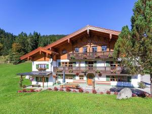 ein großes Holzhaus mit Balkon auf einem Hügel in der Unterkunft Auf'm Feggenlehen in Ramsau bei Berchtesgaden