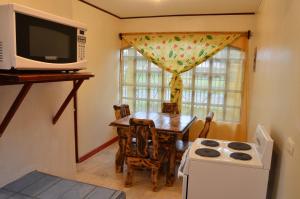 a small kitchen with a table and a microwave at Apartamentos Herrera in Puerto Jiménez +13 photos