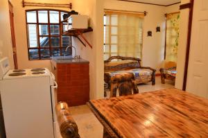 ein Wohnzimmer mit einem Kühlschrank und einem Tisch. in der Unterkunft Apartamentos Herrera in Puerto Jiménez