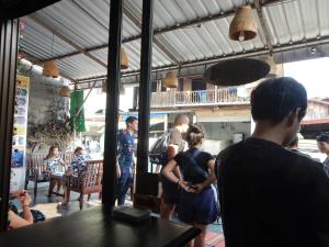 um grupo de pessoas em pé em torno de um restaurante em Vang Vieng Camellia Hotel em Vang Vieng