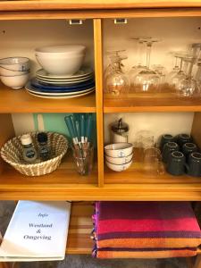 a wooden shelf with bowls and dishes on it at Tuynhuys in s-Gravenzande
